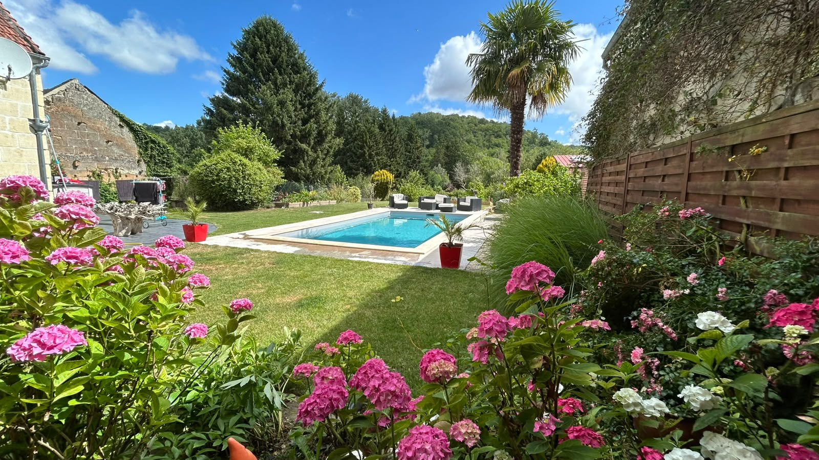 Piscine enterrée Piscines du Nord dans un jardin fleuri